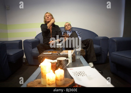 Rick Parfitt (left) and Francis Rossi (right) of the rock bank Status Quo sit on a sofa in a dressing room. Stock Photo