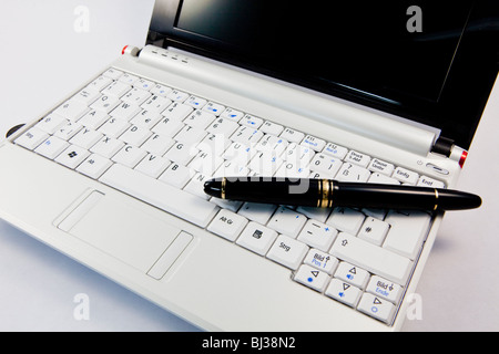 Laptop, netbook, and a fountain pen on the keyboard Stock Photo