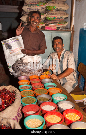 India, Kerala, Calicut, Kozhikode, Halwa Bazaar, men showing plates of different dried pulse samples in wholesaler Stock Photo