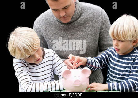 Father teaching sons to save Stock Photo