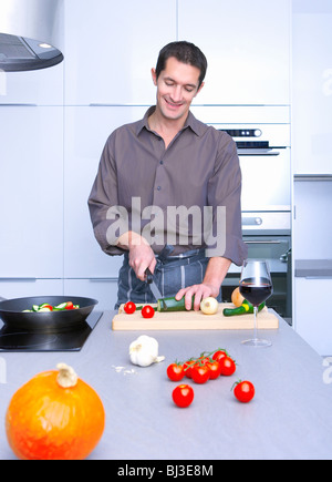 man cooking in a kitchen, and smiling Stock Photo