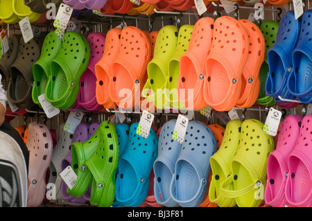 Display (close-up) of bright colourful Croc sandals (Crocs) for sale, price tag labels attached - open-air market trade stall, Yorkshire, England, UK. Stock Photo