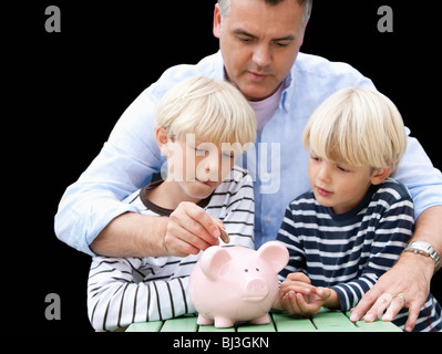 Father teaching sons to save Stock Photo