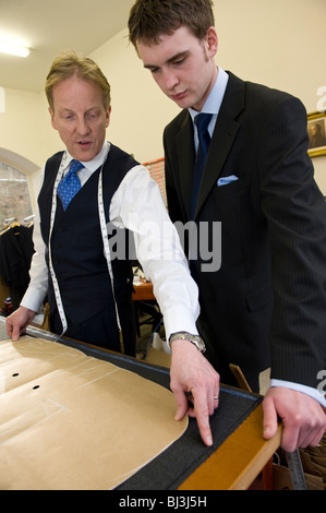 Master tailor Thomas Mahon instructing his new apprentice the trade of tailoring at his Carlisle base Warwick Hall, Cumbra uk Stock Photo