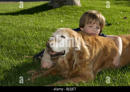 Boy and dog resting in the grass