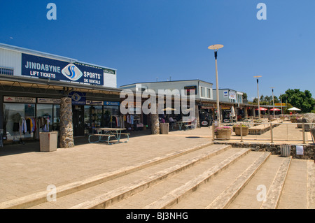 Retail Shops Jindabyne New South Wales | JINDABYNE, New South Wales — Ski rental and lift-ticket storefronts line a commercial plaza in Jindabyne, gateway town to the Snowy Mountains resorts of Thredbo and Perisher. This retail district dates to the 1960s, built on higher ground after the original township was flooded by the Jindabyne Dam during construction of the Snowy Mountains Hydro-Electric Scheme. Stock Photo