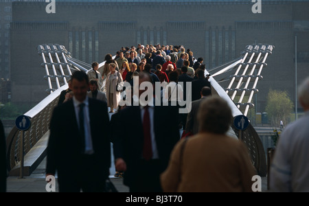 Pedestrians walk in spring sunshine over the newly re-opened Millennium Bridge over London's River Thames. Stock Photo