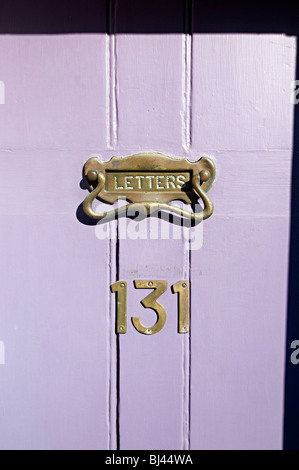 door knocker on purple wooden door and letter and 131 as the number Stock Photo