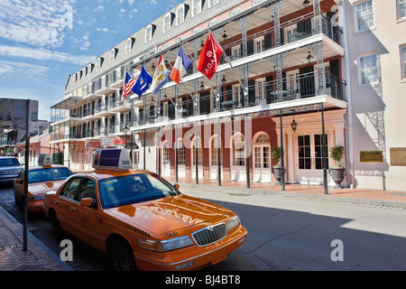 Yellow taxi cabs parked in front of the Inn On Bourbon hotel. Bourbon street, French Quarter, New Orleans, Louisiana, USA. Stock Photo
