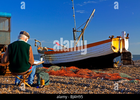 Artist painting fishing boat on the beach at Aldeburgh a fishing town in Suffolk East Anglia England UK Stock Photo