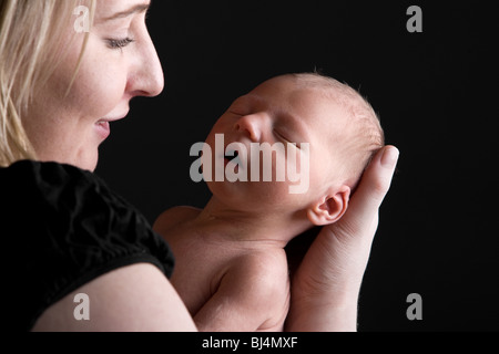 Shot of a Young Mother Smiling whilst Holding her Newborn Child Stock Photo