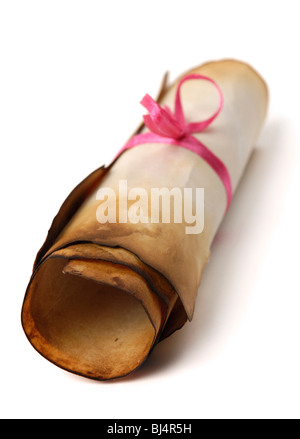 Roll of yellowish burnt vintage parchment tied with a red ribbon Isolated over white background Stock Photo
