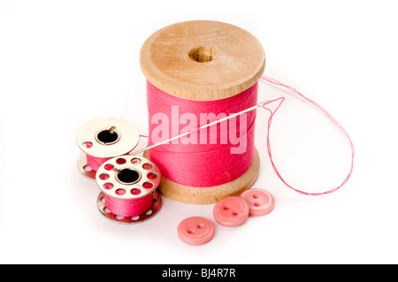 Premium Photo  A spool of pink thread a needle and a thimble on a pink  background