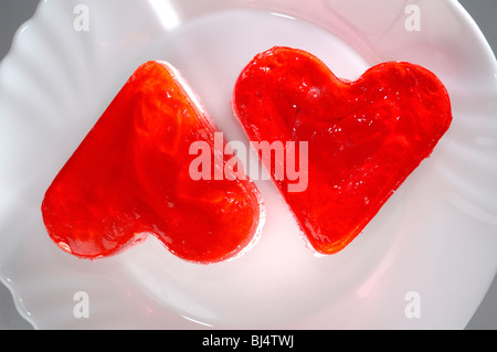 Two heart-shaped appetizing petit four cakes on a plate Stock Photo