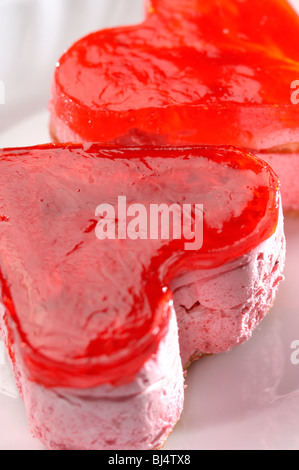 Two heart-shaped appetizing petit four cakes on a plate Stock Photo