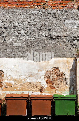 Three refuse bins on wall background. Stock Photo