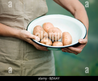 A female holding a bowl of potatoes Stock Photo