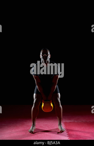 man lifting kettle bell, front on Stock Photo