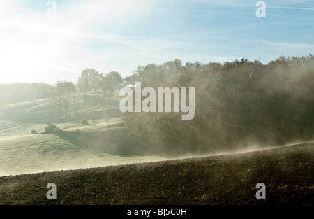 Early morning mist rising over frosty fields in France Stock Photo