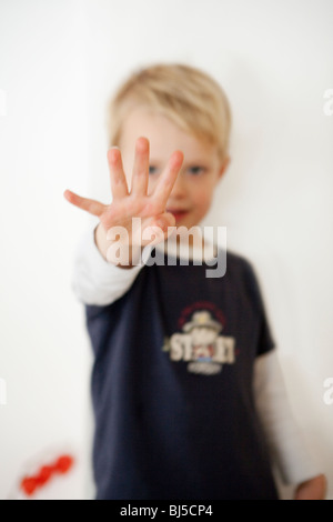 Boy pointing four fingers Stock Photo