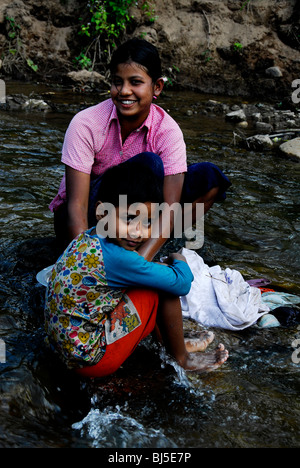 karen mother and child washing clothes in stream,mae la  refugee camp(thai burmese border) ,north of mae sot,thailand Stock Photo