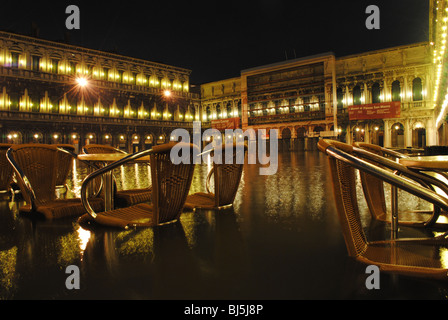 Flooded tables and chairs at night in St Mark's Square, Venice, Italy Stock Photo