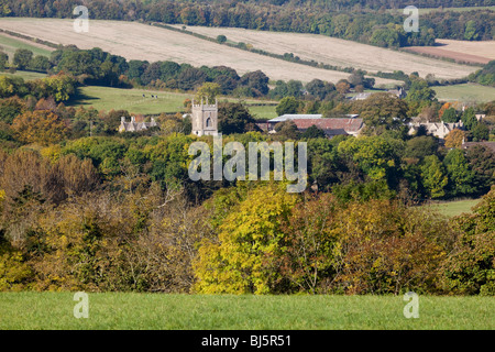 The tower of St Michael & All Angels church marks the position of the Cotswold village of Withington, Gloucestershire Stock Photo