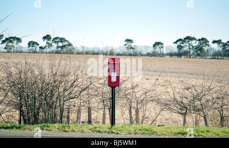 red post box on a country road, suffolk, UK Stock Photo