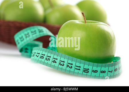 green apple and measuring tape on white background Stock Photo
