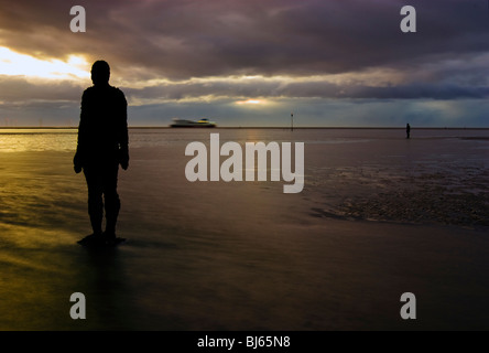 Colouful sunset at Crosby beach, with one Of Anthony Gormly Statues Stock Photo