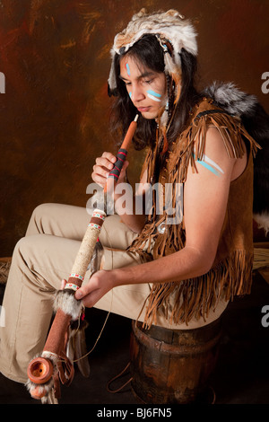 Portrait of an Indian in traditional costume wearing eagle feathers, coyote fur and beads Stock Photo
