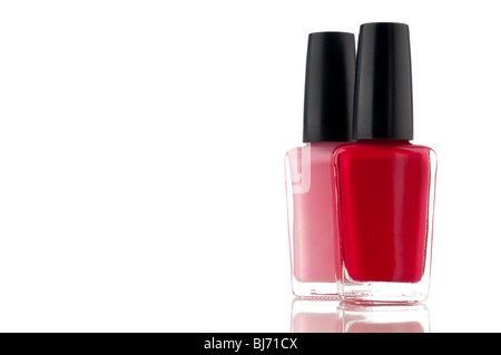 Horizontal image of red and pink nail polish on a white reflective surface Stock Photo