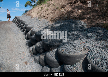 Recycled tyres and gravel used as a retaining wall on a driveway Stock Photo