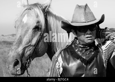 A horse rider looking confused next to his horse his horse. Stock Photo