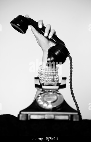 Woman's hand holding telephone receiver Stock Photo
