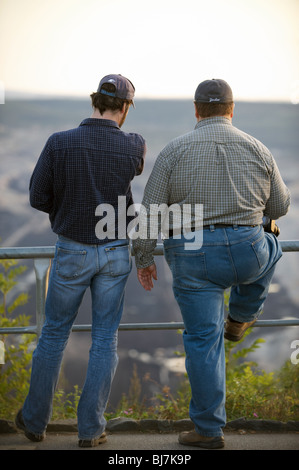 Two men overlooking an open cast coal mine, Germany. Stock Photo