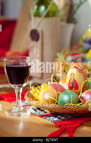 Easter colorful eggs and wine glass on table Stock Photo