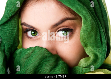 Portrait of mysterious beautiful Caucasian Hispanic Latina woman face with green penetrating eyes and green fashion scarf wrap. Stock Photo