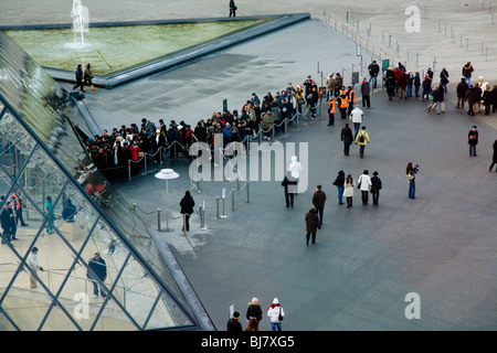 People queue for free entry to The Louvre Museum / Musee / Palais du Louvre, beside the Glass Pyramid. Paris, France. Stock Photo