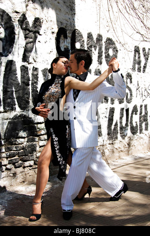 Tango dance couple demonstrate a tango dance move against a graffiti black and white wall in La Boca, Buenos Aires, Argentina Stock Photo