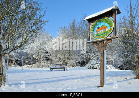 Winter wonderland snow covered Doddinghurst village green and sign on a blue sky day near Brentwood Essex England UK Stock Photo