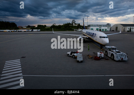 A ryanair aeroplane parked at an airport in evening light under threathening clouds Stock Photo