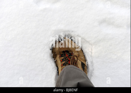 Walking boot and footprint in snow. FULLY MODEL RELEASED Stock Photo