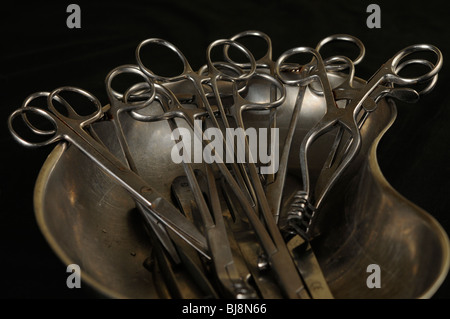 Stainless steel medical instruments laid out in a kidney dish used for embalming Stock Photo