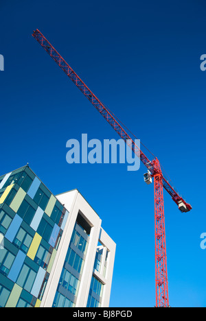 A red construction crane set against a bright blue sky. Stock Photo