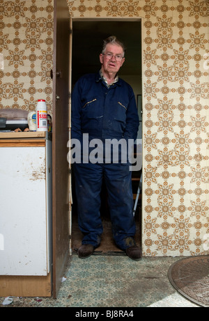Senior man in overalls standing in a doorway in his motor home Stock Photo