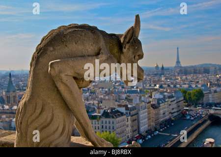 One of the Gargoyles on Notre Dame Cathedral, looking out over the Seine river and Paris, with the Eiffel Tower in the distance Stock Photo