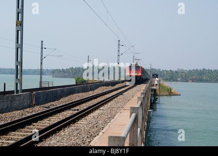 Fast Moving Indian Express Electric Train through the Beautiful Kerala landscape and Backwaters.A Bridge View from Kerala,India Stock Photo