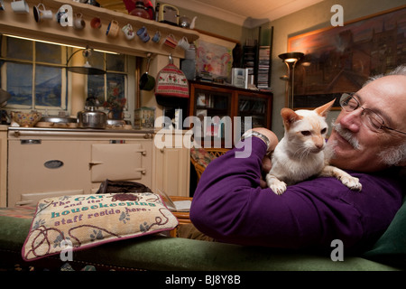 senior man with cat in his living room Stock Photo