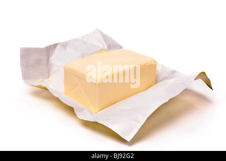 Piece of butter in paper on a white background. Shallow focus Stock Photo